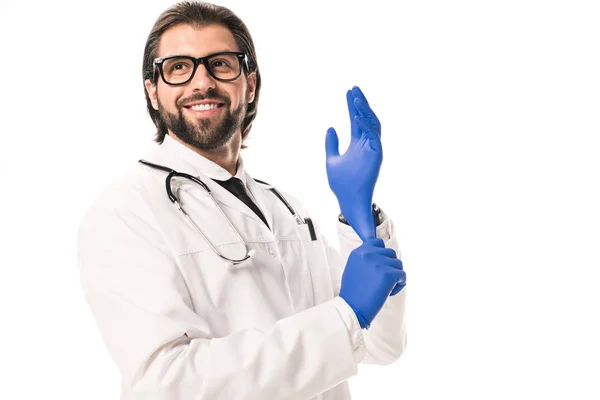 Low angle view of smiling doctor wearing medical gloves and looking away isolated on white — Stock Photo