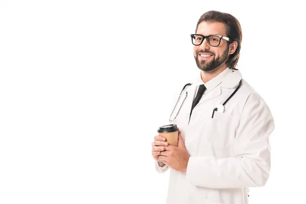 Schöner lächelnder Arzt, der Kaffee to go hält und isoliert auf weißem Grund wegschaut — Stockfoto