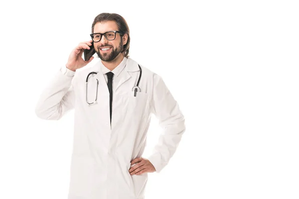 Glücklicher Arzt in Brille und weißem Kittel, der mit dem Smartphone auf weißem Grund spricht — Stockfoto
