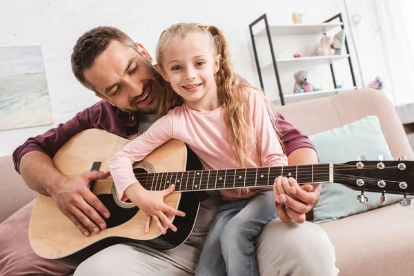 Dad and daughter having fun and playing on guitar — Stock Photo
