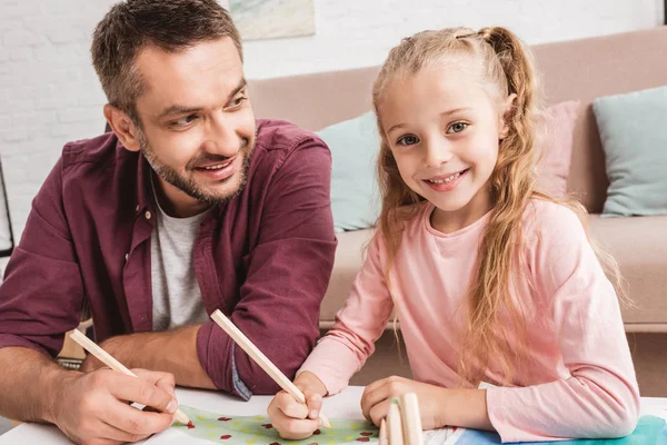 Alegre pai e filha se divertindo e desenhando em casa — Fotografia de Stock