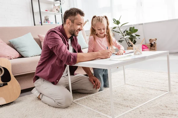 Padre e figlia si divertono e disegnano a casa — Foto stock