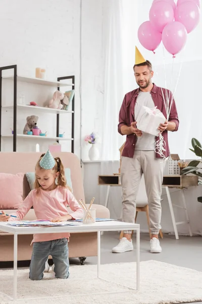Pai preparando presente e balões rosa para filha — Fotografia de Stock
