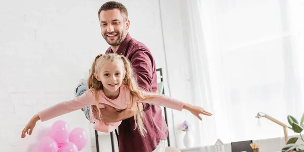 Padre sosteniendo hija en brazos y divertirse - foto de stock