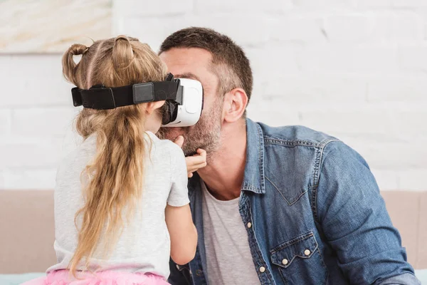 Pai e filha sorrindo usando fone de ouvido realidade virtual juntos em casa — Fotografia de Stock