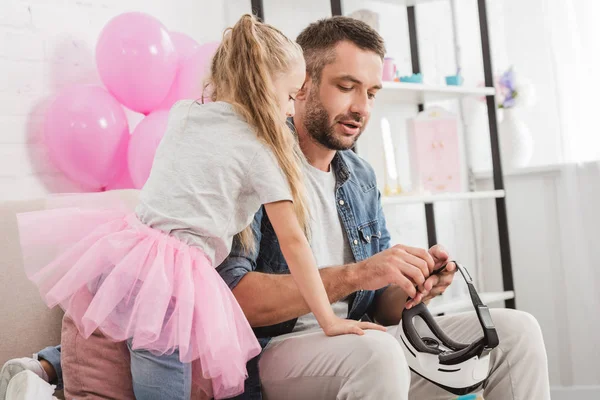 Bonito pai e bonito filha usando vr fone de ouvido juntos em casa — Fotografia de Stock