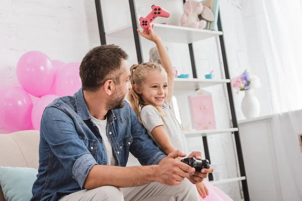 Pai e filha se divertindo e brincando com joysticks — Fotografia de Stock