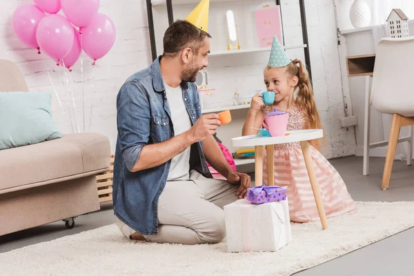 Father and daughter playing tea party at home — Stock Photo