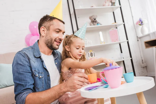 Padre e hija jugando al té en casa - foto de stock