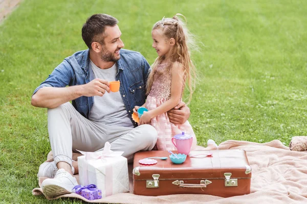 Father and daughter playing tea party at lawn — Stock Photo