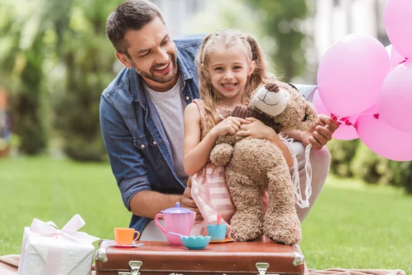 Vater und Tochter mit Teddybär spielen Teeparty auf dem Rasen — Stockfoto