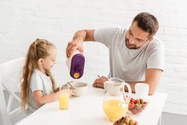 Pai e filha comendo flocos de milho na cozinha — Fotografia de Stock