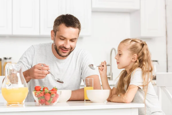 Padre e hija desayunando en la cocina - foto de stock