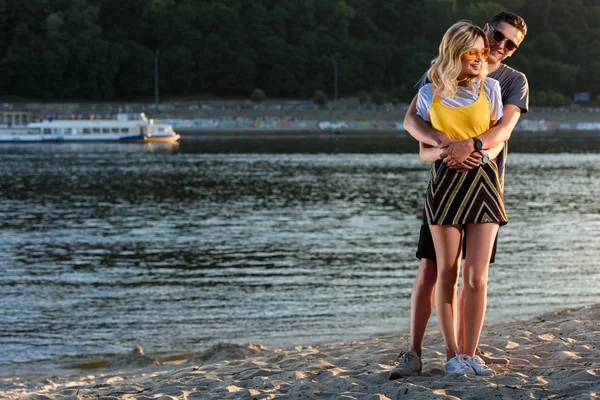 Namorado abraçando namorada na praia do rio — Fotografia de Stock
