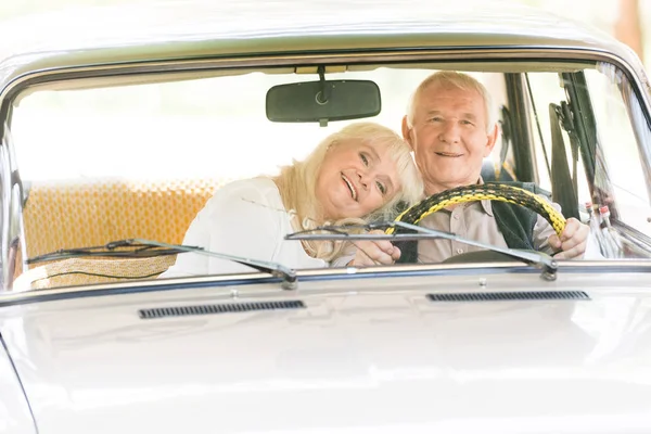 Donna anziana che abbraccia l'uomo in auto beige — Foto stock