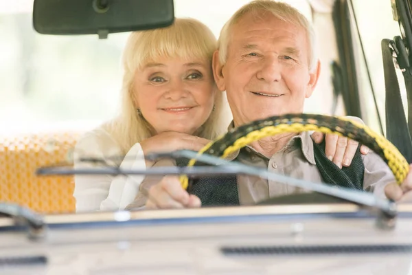 Donna anziana che abbraccia l'uomo guida in auto retrò — Foto stock