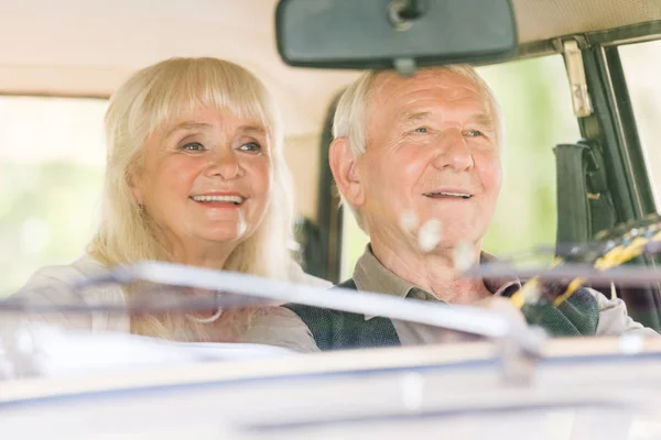 Vue de face de heureux couple de personnes âgées conduite voiture beige — Photo de stock