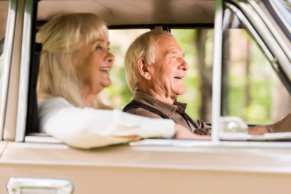 Vue latérale du beau couple de personnes âgées conduite voiture vintage beige — Photo de stock