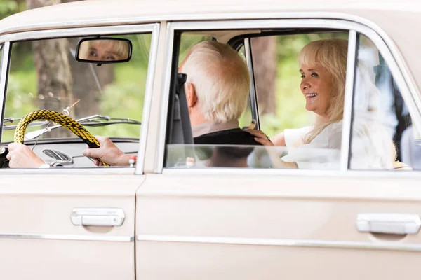 Щаслива старша пара водіння бежевий ретро автомобіль — стокове фото