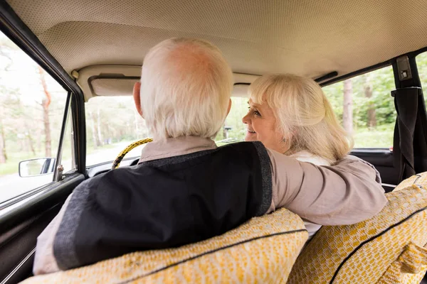 Vue arrière du mari aîné et de la femme en voiture beige — Photo de stock
