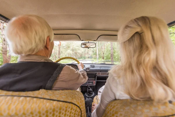 Back view of senior family in vintage car — Stock Photo