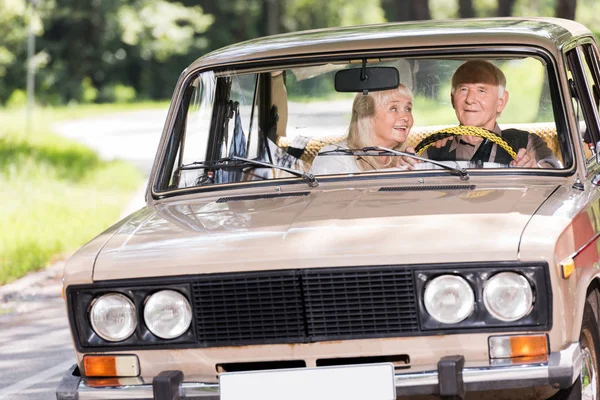 Счастливая старшая пара за рулем ретро автомобиля — стоковое фото