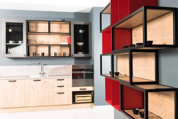 Interior de la moderna cocina de luz limpia con mostradores de cocina y estantes rojos — Stock Photo