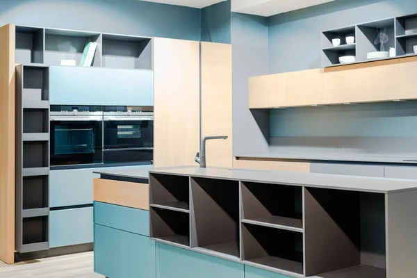 Интерьер современной деревянной голубой кухни с удобной мебелью — стоковое фото