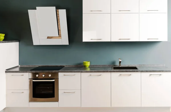 Interior of modern kitchen with white kitchen counter, stove and oven — Stock Photo