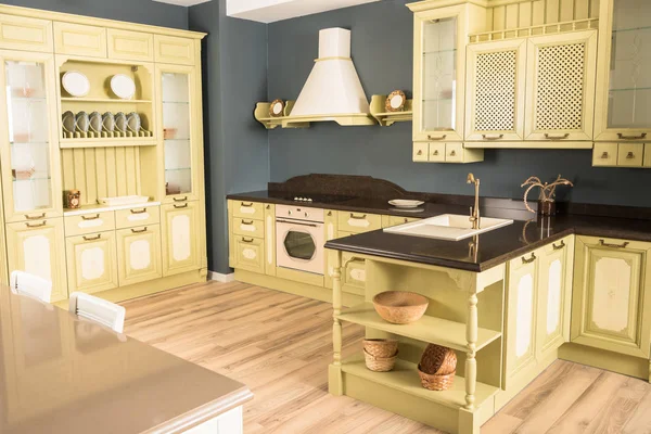 Інтер'єр сучасної зеленої світлої кухні зі зручними меблями і дерев'яною підлогою — стокове фото