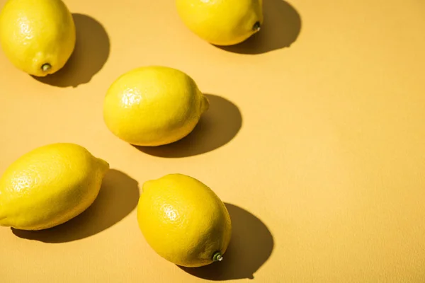 Limones frescos sobre fondo amarillo minimalista con espacio de copia - foto de stock