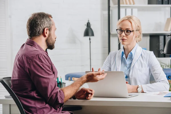 Patient having conversation with female physiotherapist during appointment in hospital — Stock Photo