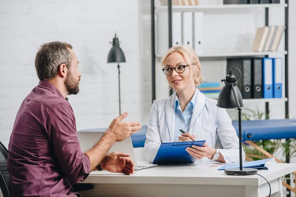 Patient im Gespräch mit Physiotherapeut bei Termin im Krankenhaus — Stockfoto