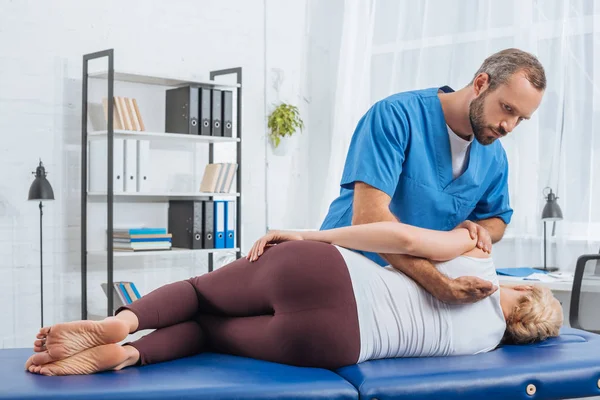 Quiroprático massagear de volta do paciente que deitado na mesa de massagem no hospital — Fotografia de Stock
