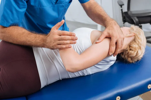 Schnappschuss von Physiotherapeut streckt Patientin auf Massagetisch im Krankenhaus — Stockfoto