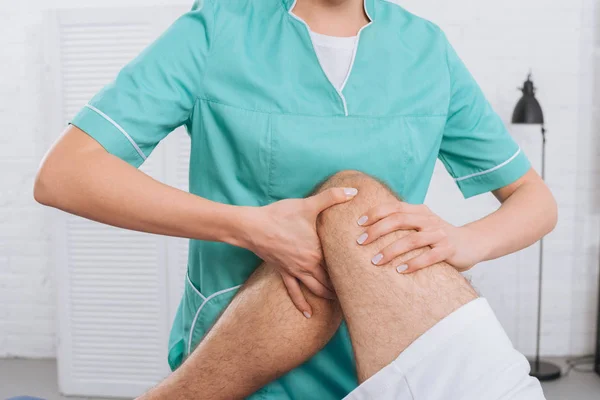 Tiro recortado de massagem terapeuta fazendo massagem nas pernas para o paciente na clínica — Fotografia de Stock