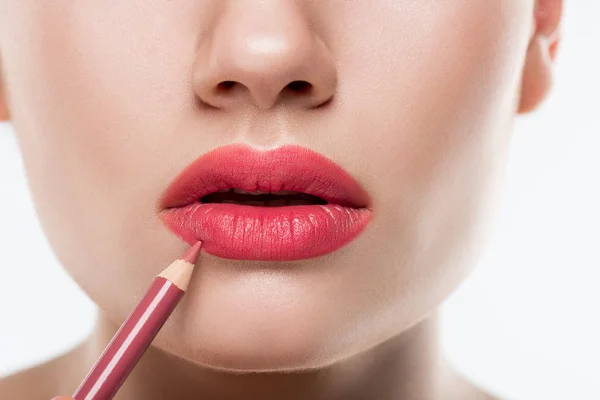 Partial view of woman applying pink lip pencil,  isolated on white — Stock Photo