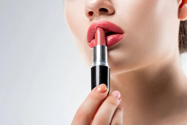 Vue partielle de fille appliquant rouge à lèvres rose, isolé sur blanc — Photo de stock