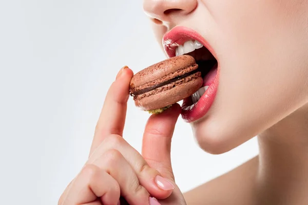 Vista cortada de mulher mordendo chocolate macaroon francês, isolado em branco — Fotografia de Stock