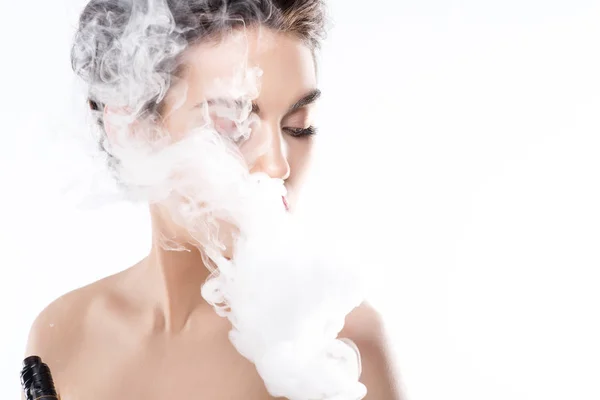 Mujer atractiva vapeo y soplado de humo, aislado en blanco - foto de stock