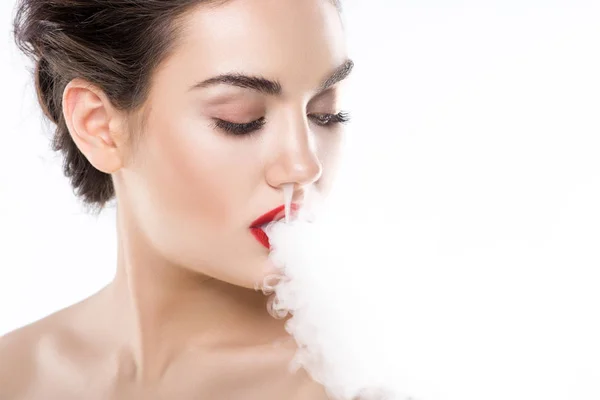 Atractiva joven mujer soplando humo, aislado en blanco - foto de stock