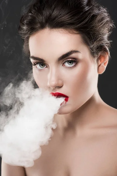 Elegante mulher nua soprando fumaça, isolado em cinza — Fotografia de Stock