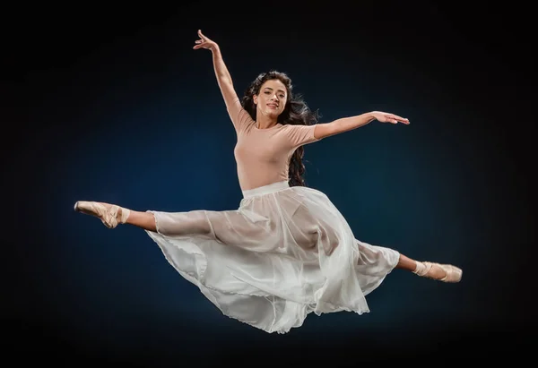 Jovem bailarina em roupas elegantes pulando no fundo escuro — Fotografia de Stock