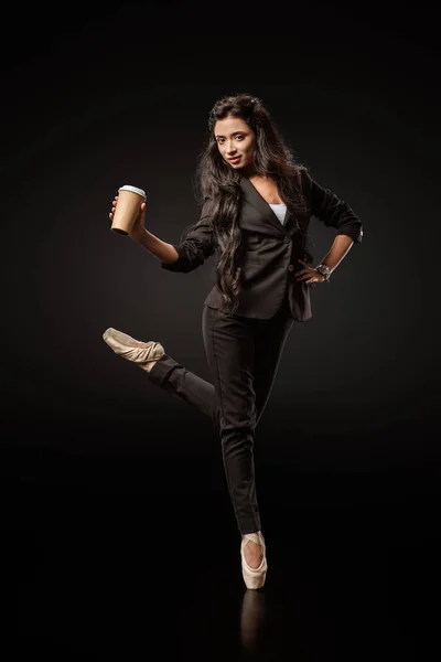 Приваблива молода бізнес-леді в формальному взутті та балеті з кавою, щоб піти на чорний фон — стокове фото