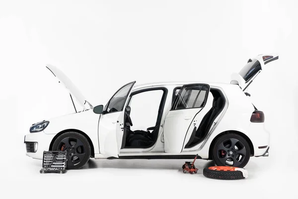 Side view of broken white car with open doors and open hood on white — Stock Photo