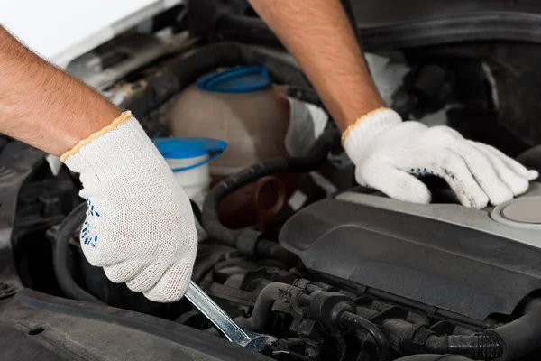 Abgeschnittenes Bild von Automechaniker, der Auto mit Schraubenschlüssel repariert — Stockfoto