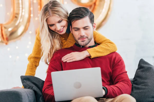 Casal feliz usando laptop em casa no ano novo — Fotografia de Stock