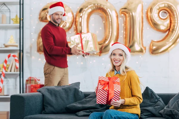 Coppia felice con regali di Natale a casa con palloncini d'oro 2019 — Foto stock