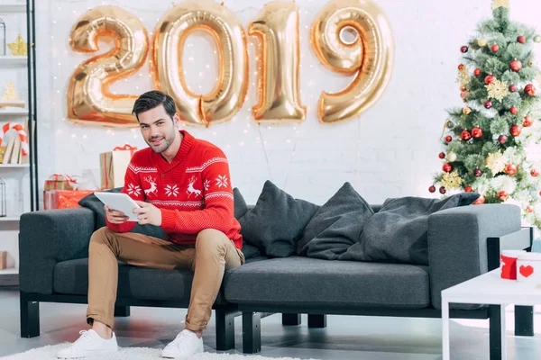 Hombre feliz utilizando la tableta digital durante 2019 año nuevo - foto de stock