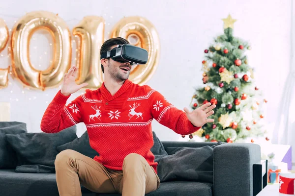 Улыбающийся человек с помощью гарнитуры виртуальной реальности в 2019 году — стоковое фото
